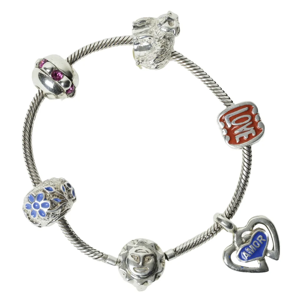 Bracelet maille serpent orné de charms : plaque « Love » émaillée rouge, cœur « Amor » bleu, fleur bleue, soleil et perle sertie de pierres roses
